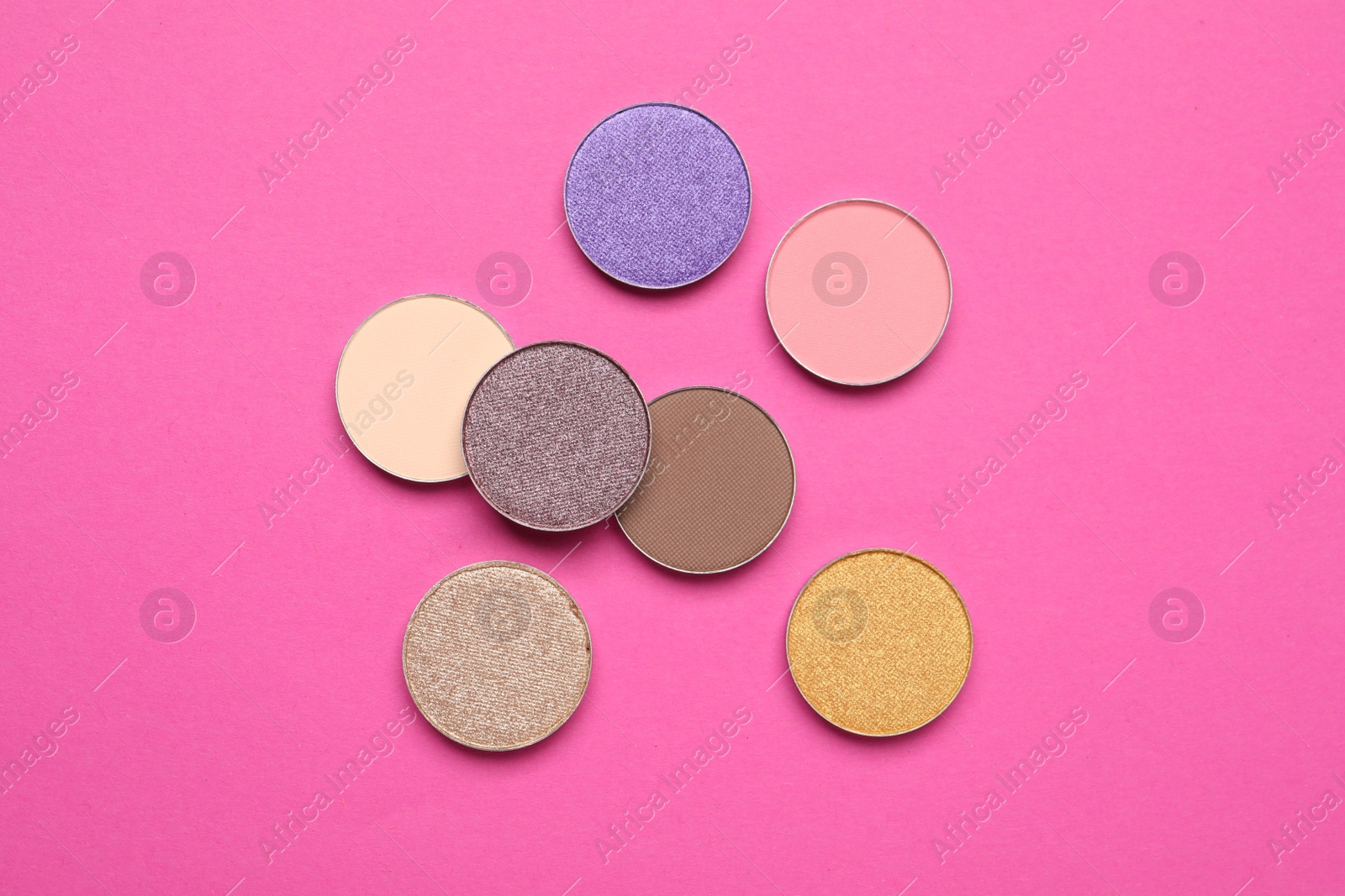 Photo of Beautiful eye shadow refill pans on pink background, flat lay