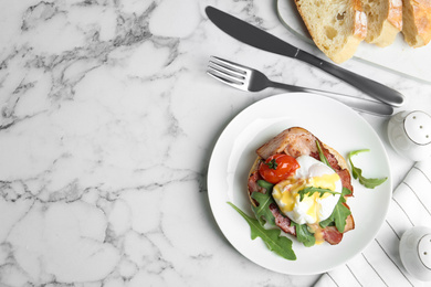 Delicious egg Benedict served on white marble table, flat lay. Space for text