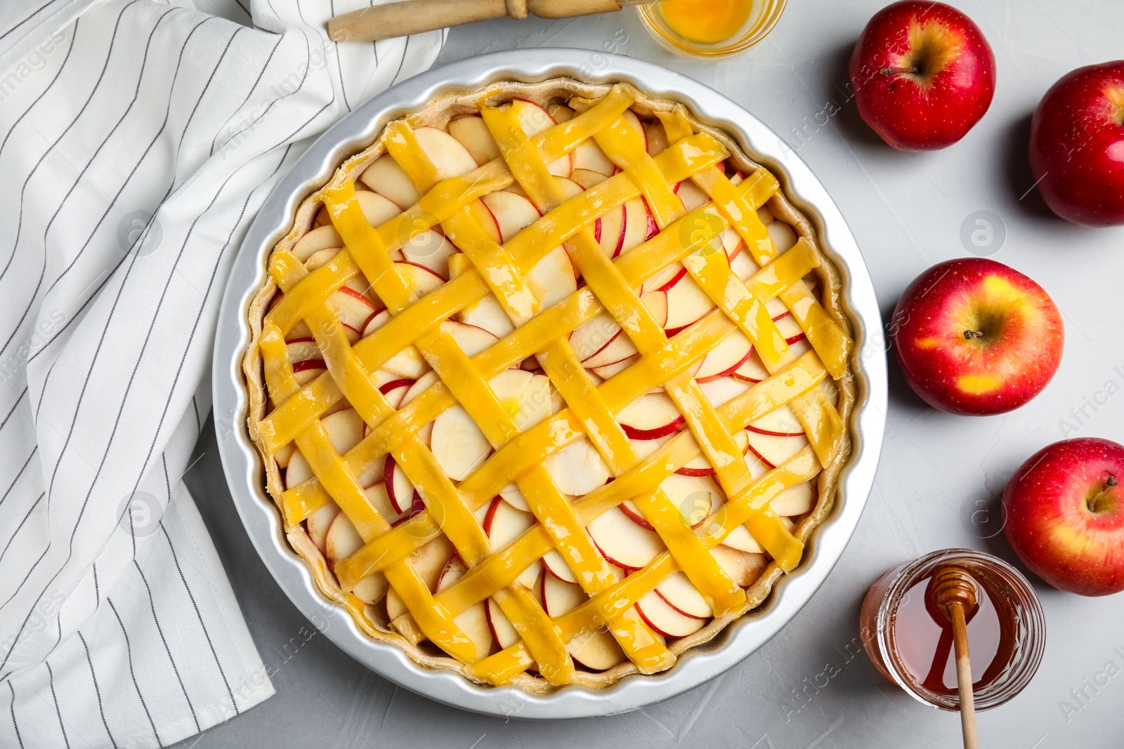 Photo of Raw traditional English apple pie in baking dish on light grey table, flat lay