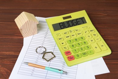 Image of Budget plan. Calculator, house model and documents on wooden table