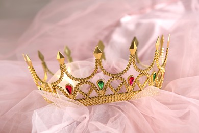 Photo of Beautiful gold tiara with gems on light cloth