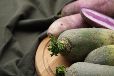 Green and purple daikon radishes on table, closeup