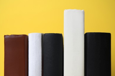 Photo of Collection of hardcover books on yellow background, closeup