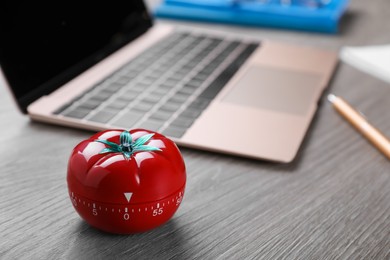 Photo of Kitchen timer in shape of tomato and laptop on wooden table, space for text