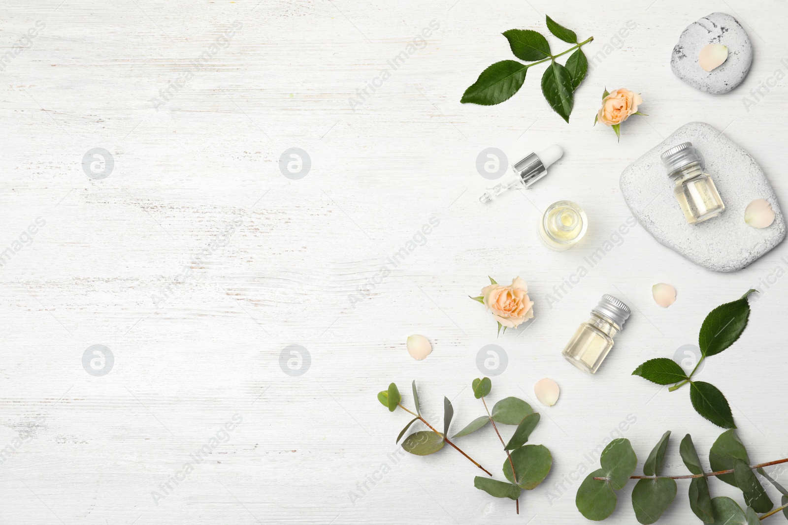 Photo of Essential oil, ingredients and space for text on wooden background, flat lay