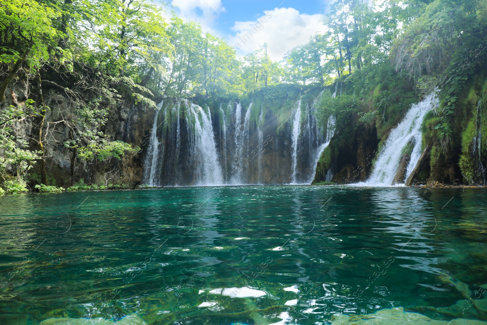 Photo of Picturesque view of beautiful waterfall and lake on sunny day