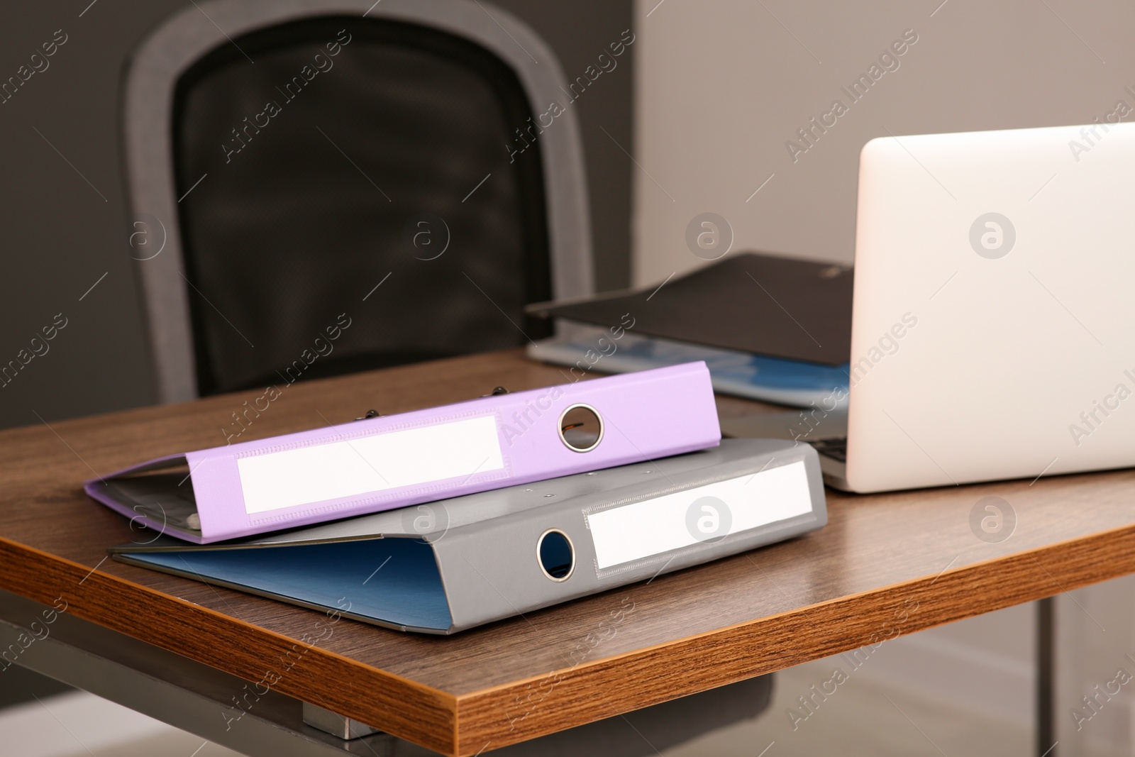 Photo of File folders near laptop on wooden table in office