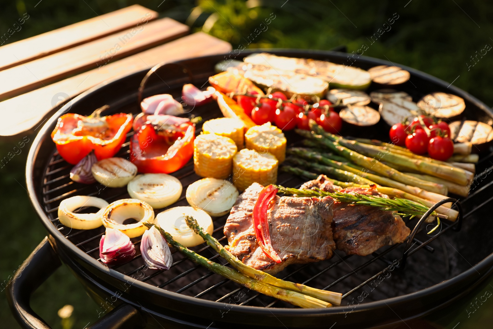 Photo of Delicious grilled vegetables and meat on barbecue grill outdoors, closeup
