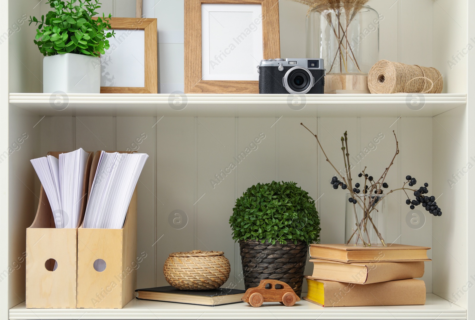 Photo of White shelving unit with different decorative elements