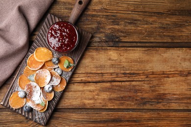 Cereal pancakes with jam and blueberries on wooden table, flat lay. Space for text