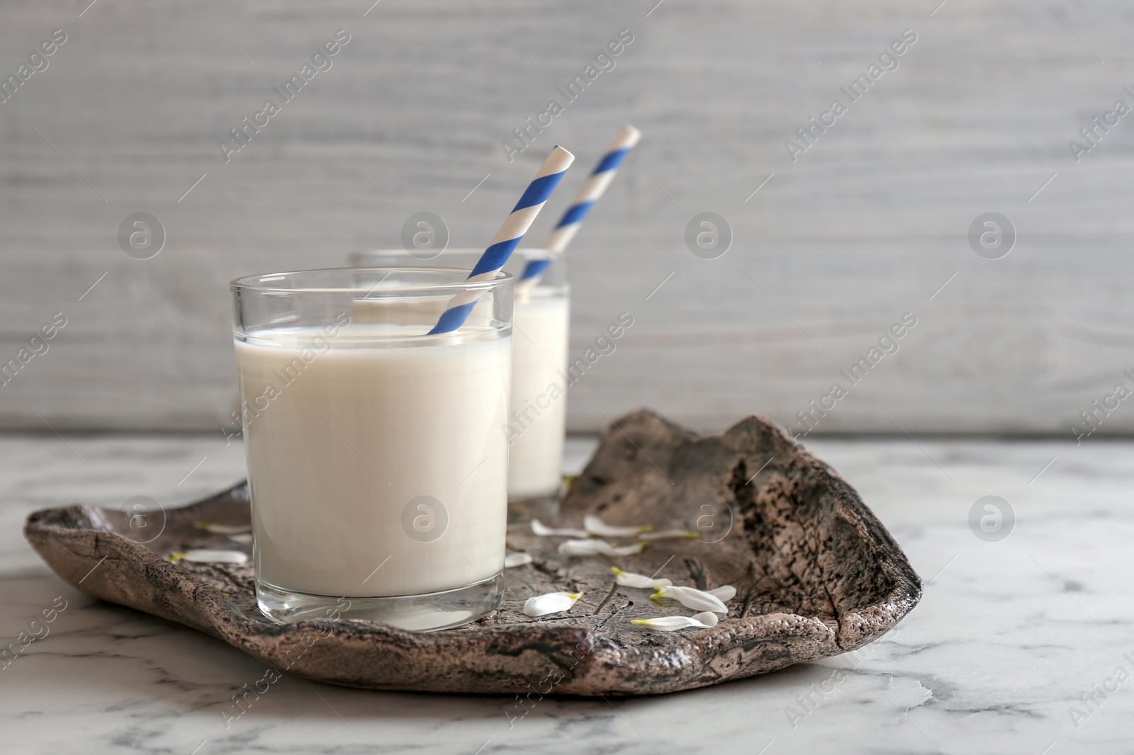 Photo of Glasses of milk with straws on plate