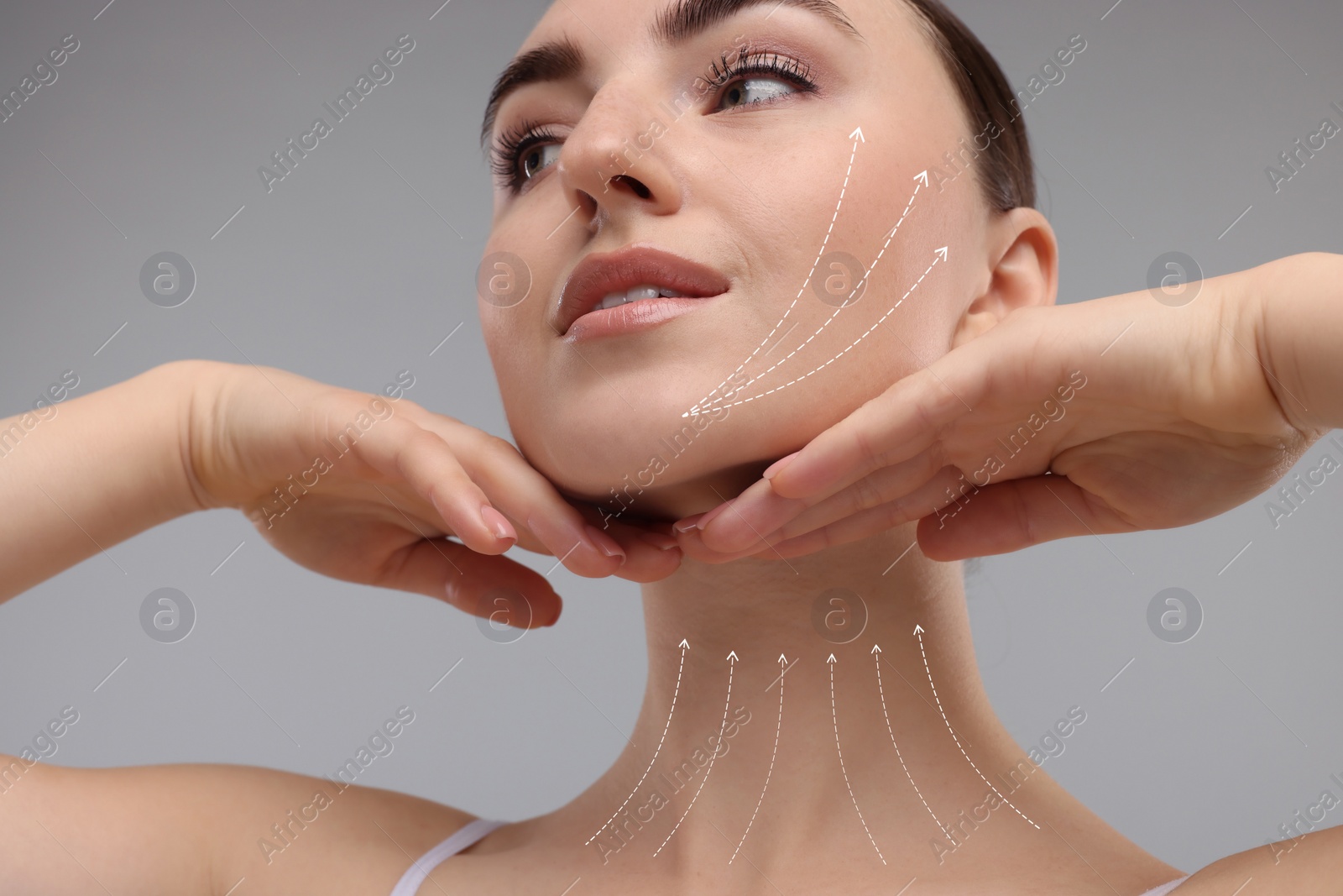 Image of Woman with perfect skin after cosmetic treatment on grey background. Lifting arrows on her neck and face