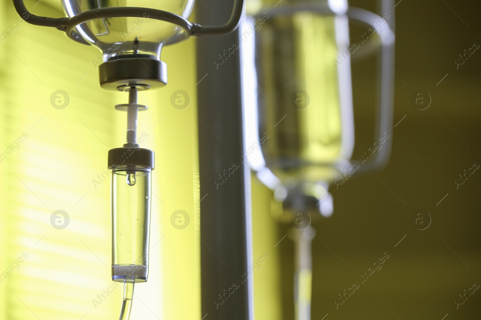 Photo of IV drip against blurred yellow background, space for text