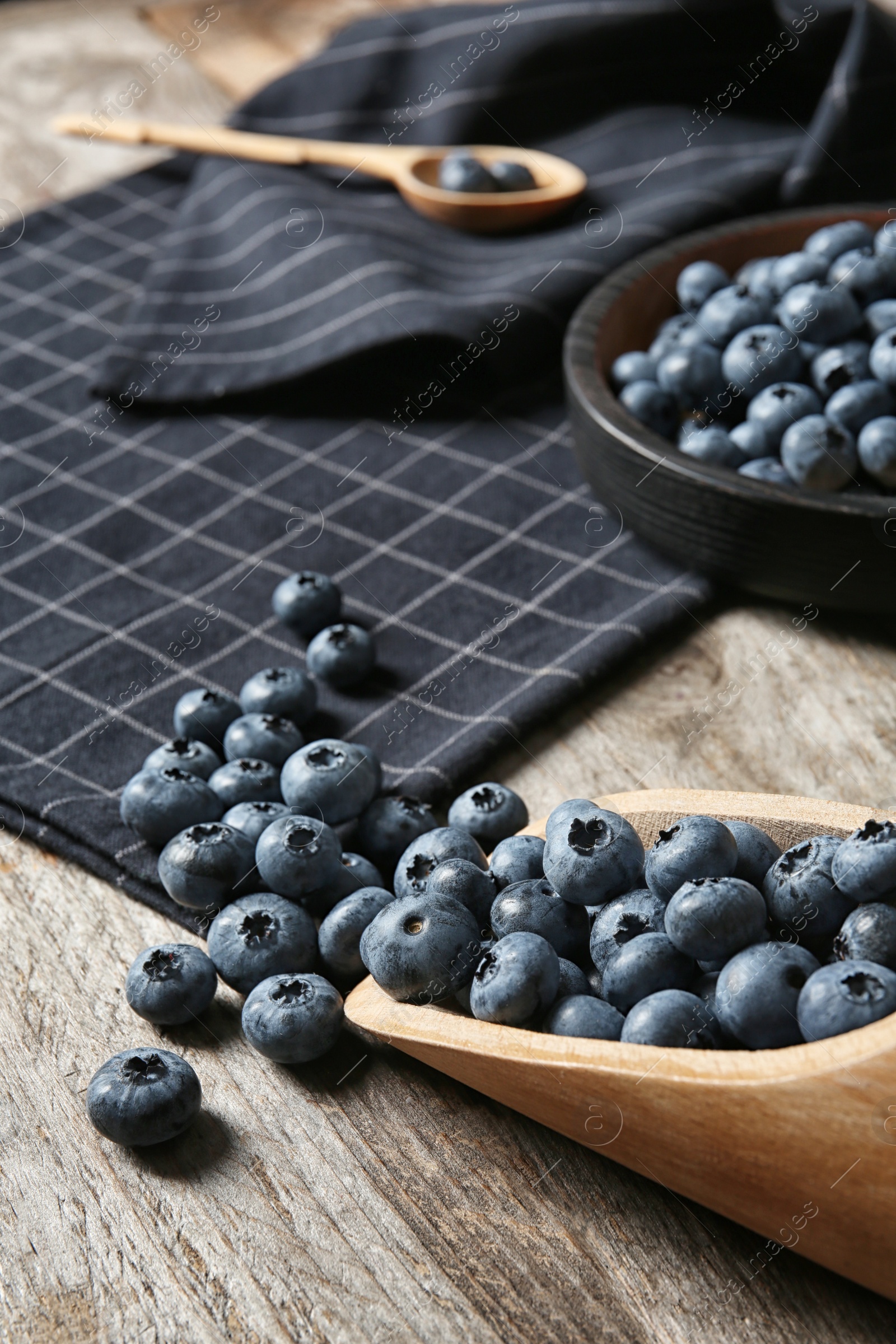 Photo of Dishware with juicy and fresh blueberries on wooden table