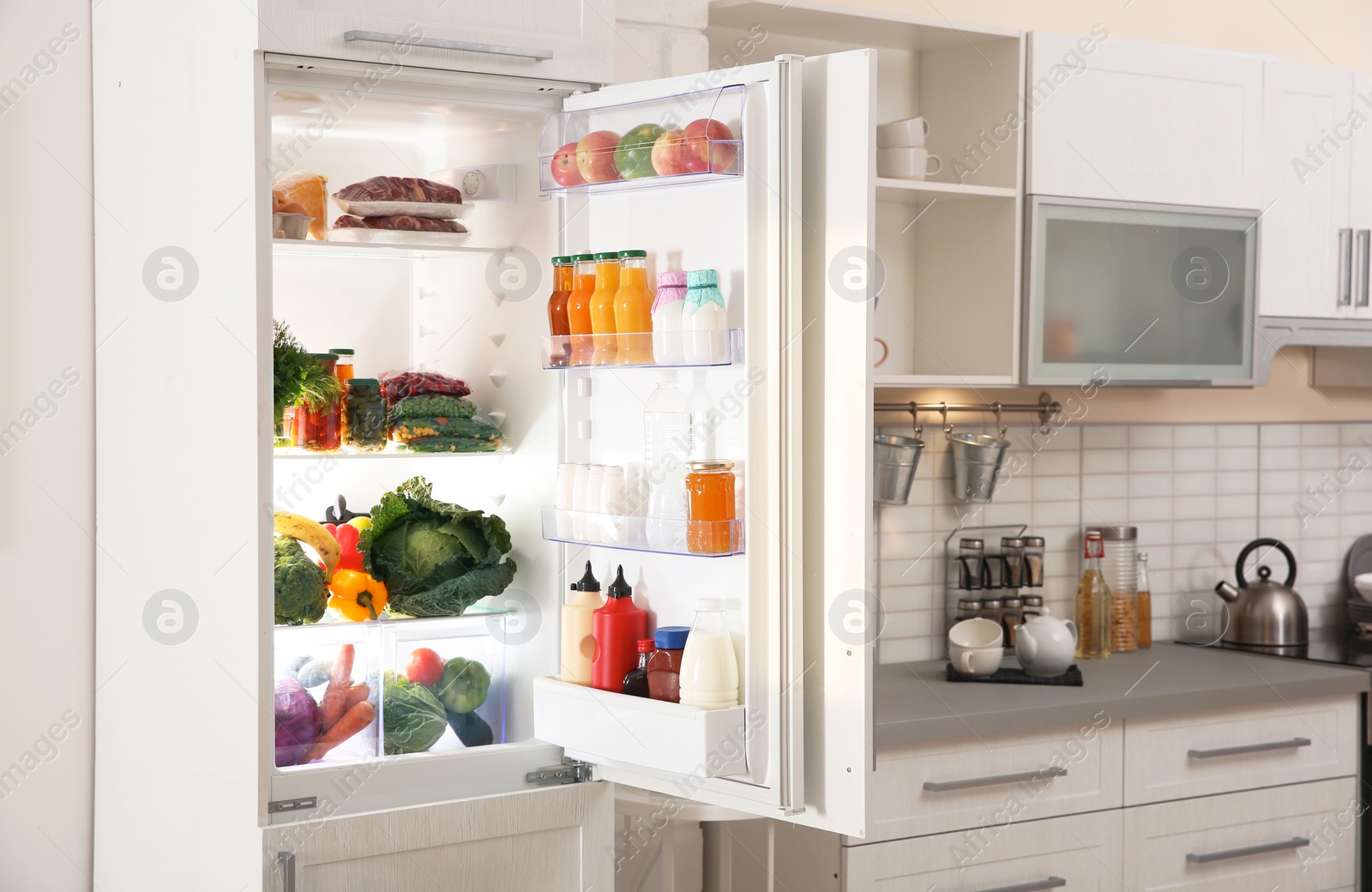 Photo of Stylish kitchen interior with refrigerator full of products