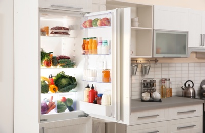 Photo of Stylish kitchen interior with refrigerator full of products