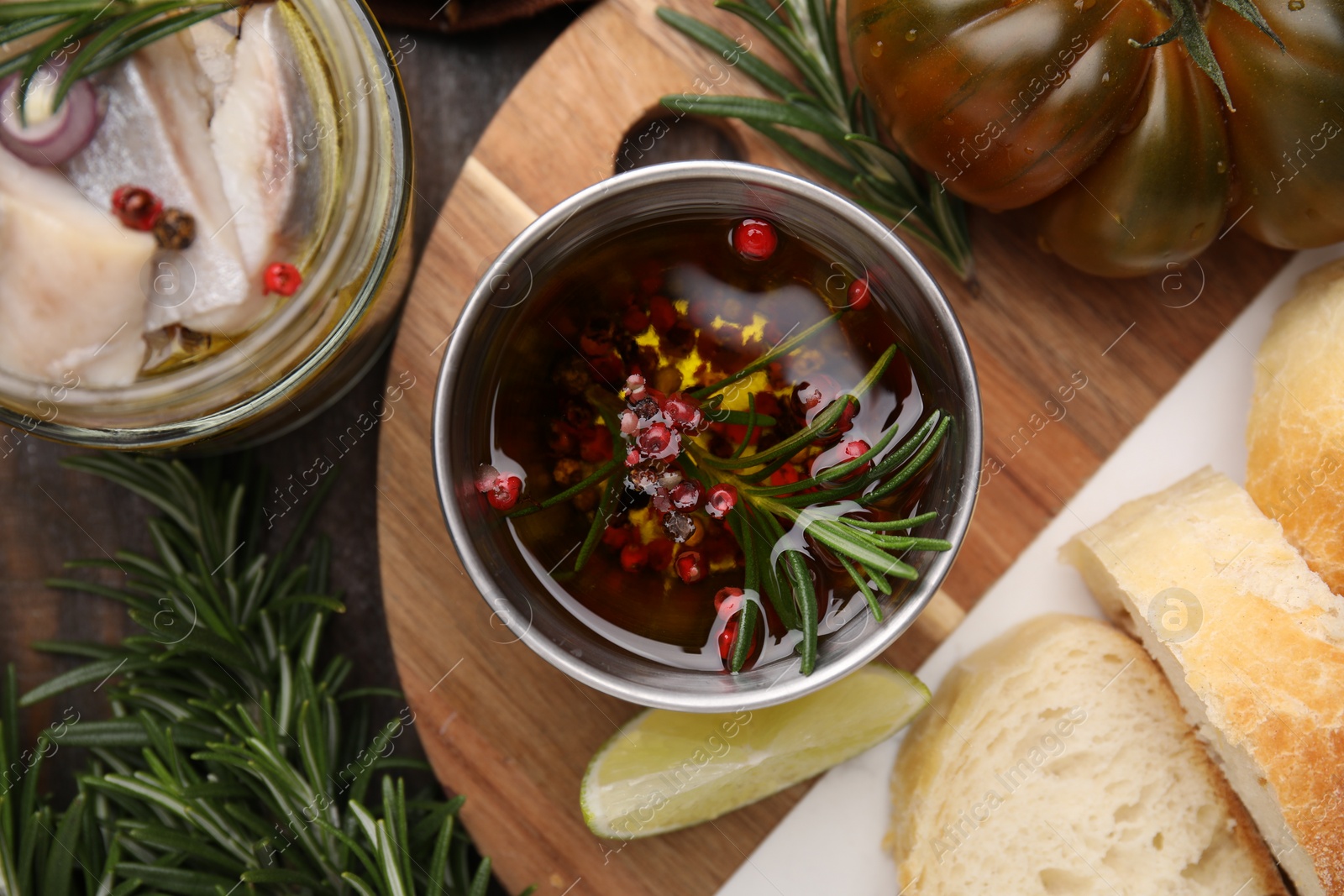 Photo of Tasty fish marinade with rosemary in bowl on wooden table, flat lay