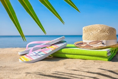 Set with stylish beach accessories on sand near sea