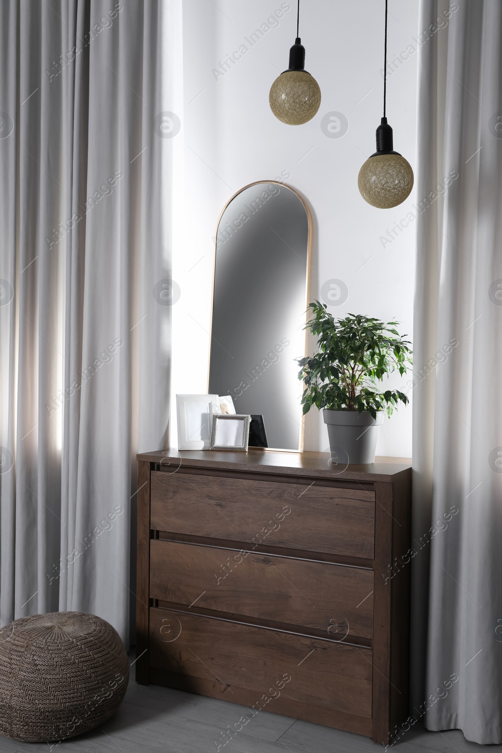 Photo of Stylish room interior with wooden chest of drawers and beautiful decor elements