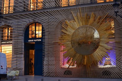 Paris, France - December 10, 2022: Facade of Louis Vuitton store with beautiful golden decoration