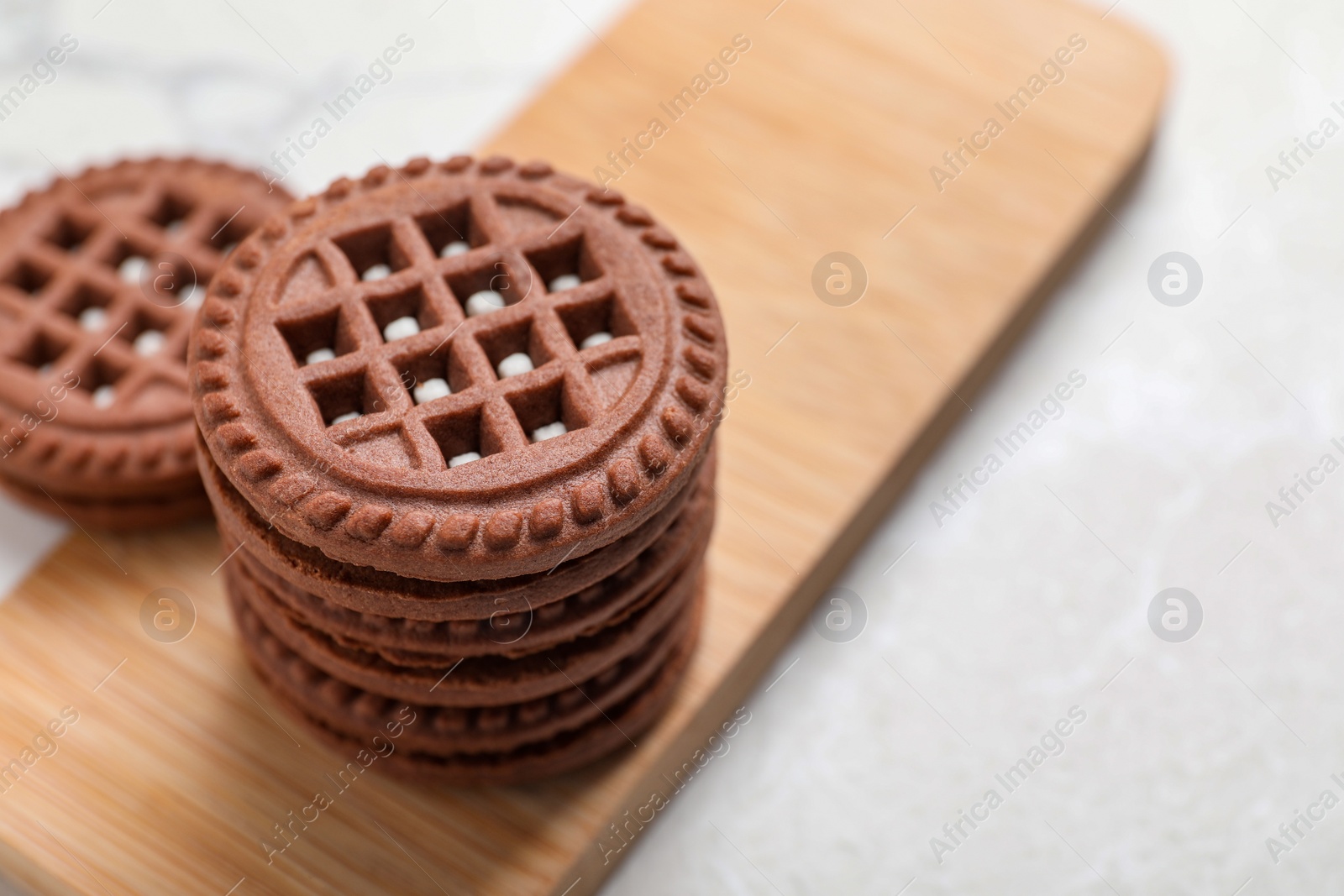 Photo of Tasty chocolate sandwich cookies with cream on light table, space for text