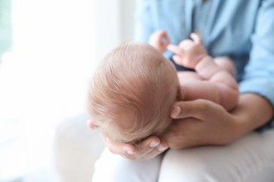 Photo of Mother holding her newborn baby at home, closeup