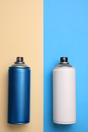 Photo of Cans of different spray paints on color background, flat lay with space for text. Graffiti supplies