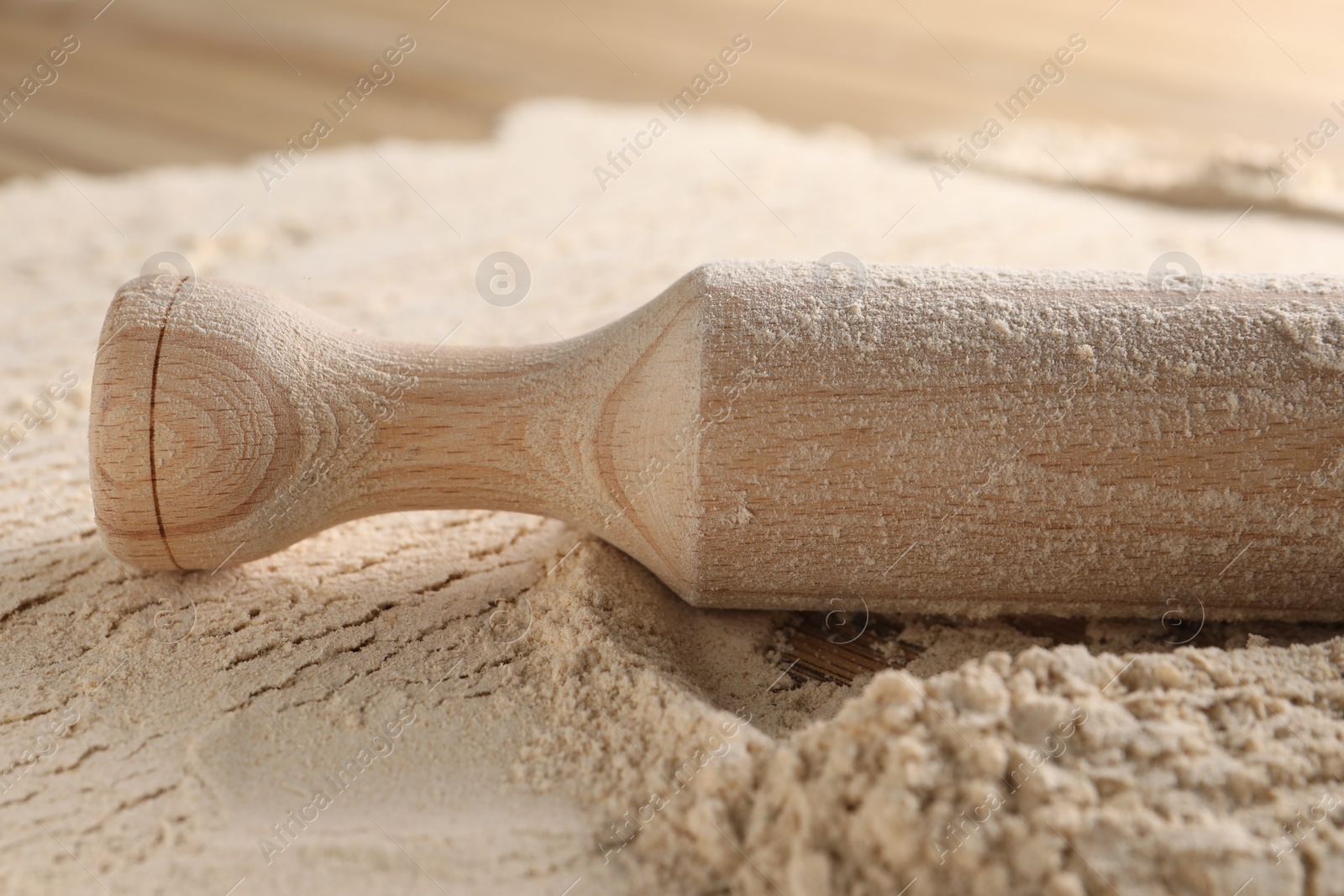 Photo of Flour and rolling pin on table, closeup