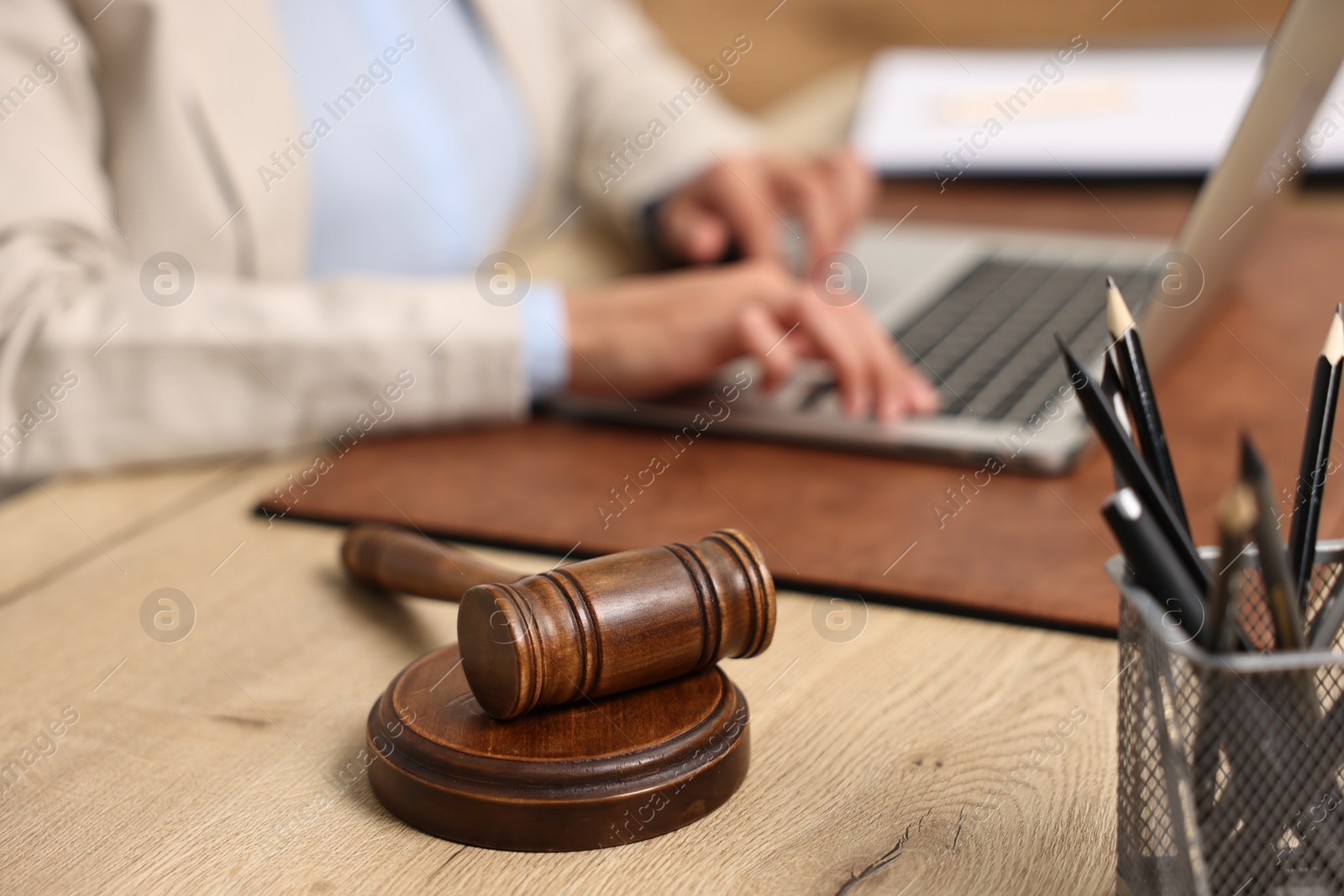 Photo of Notary using laptop at workplace in office, focus on mallet