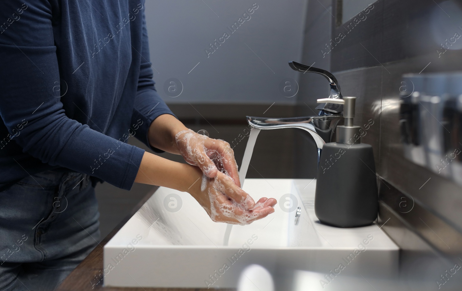 Photo of Woman washing hands in bathroom, closeup view