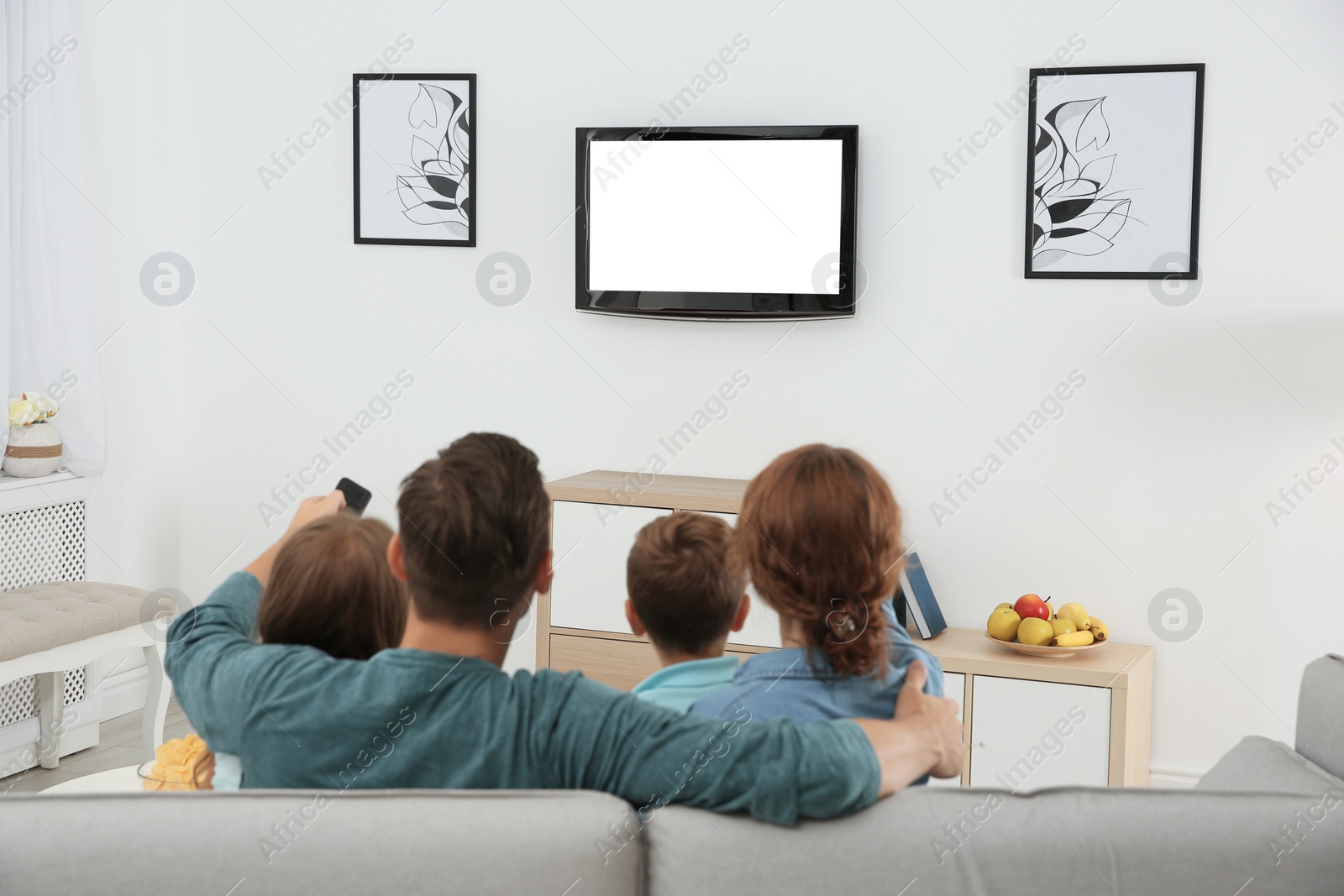 Photo of Family watching TV in room at home