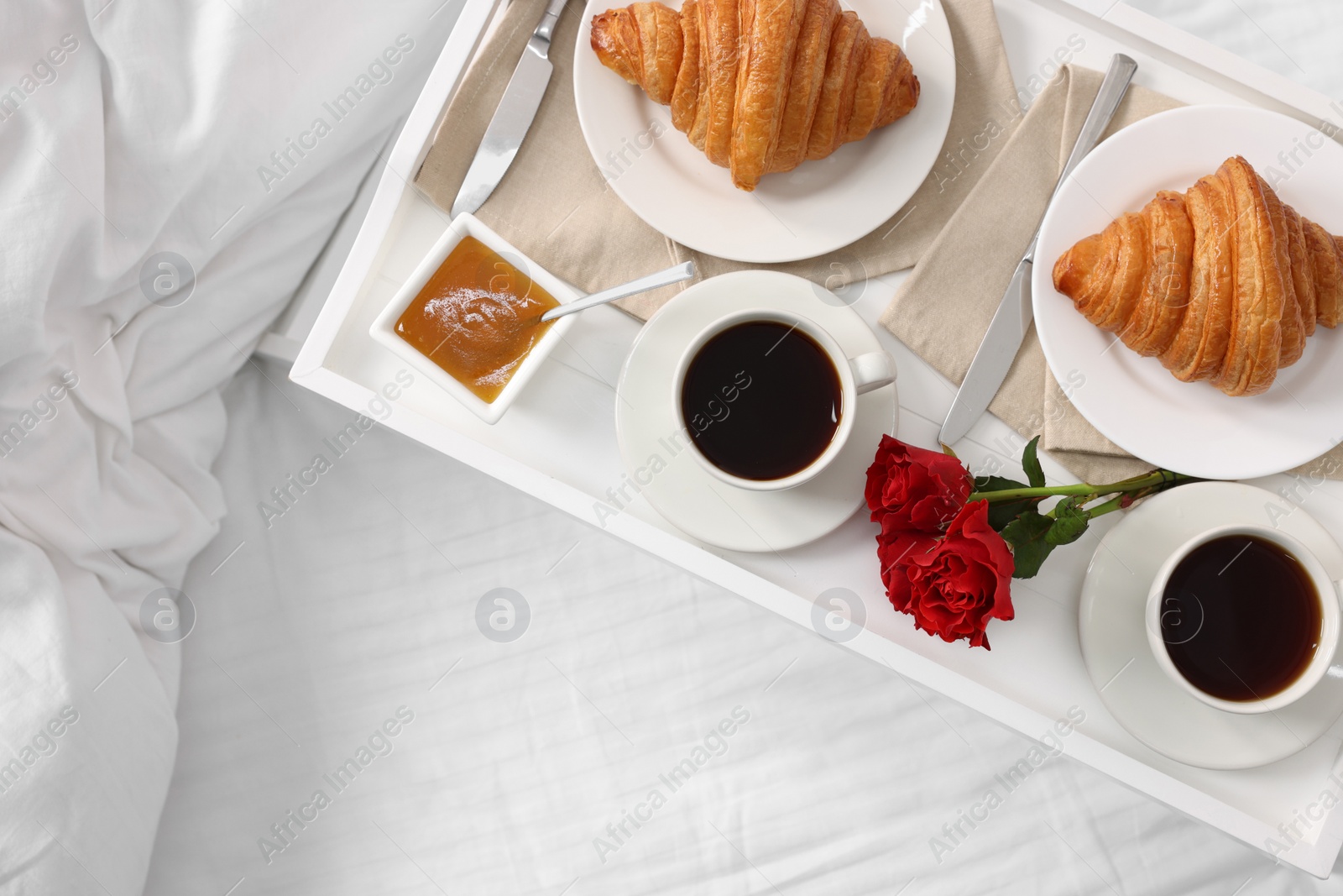 Tasty breakfast served in bed. Fresh croissants, coffee and honey on tray, top view. Space for text Photo of Tasty breakfast served in bed. Fresh croissants, coffee and honey on tray, top view. Space for text