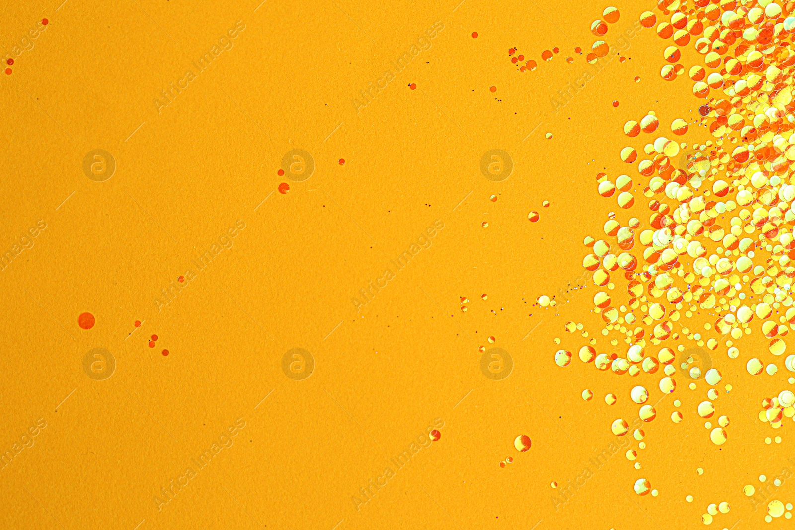 Photo of Shiny bright glitter on yellow background. Space for text