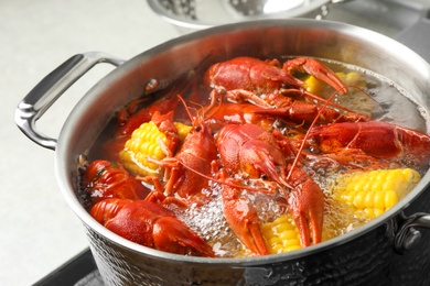Photo of Fresh delicious crayfishes in boiling water, closeup
