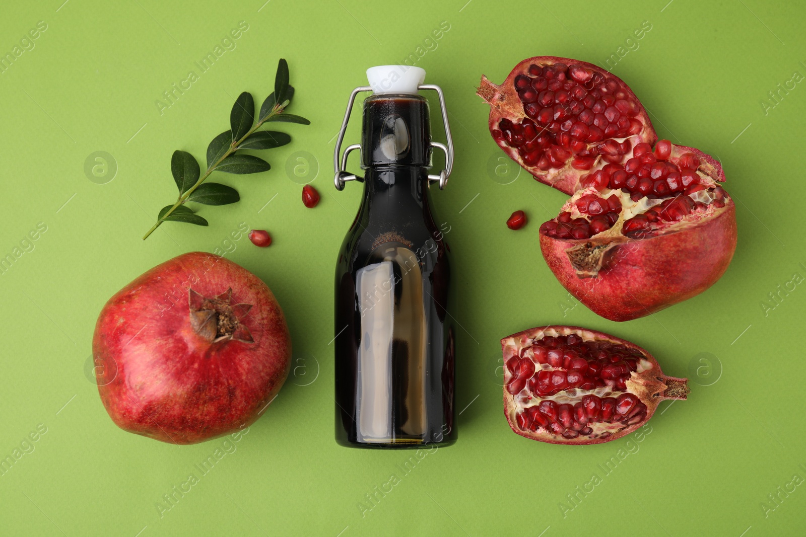 Photo of Flat lay composition with tasty pomegranate sauce and fruit on green table