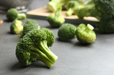 Photo of Fresh green broccoli florets on grey table, closeup. Space for text