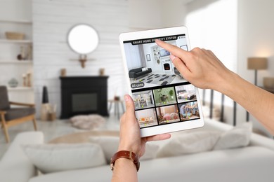Man using smart home security system on tablet computer indoors, closeup. Device showing different rooms through cameras
