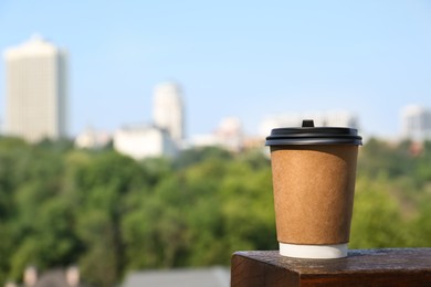 Photo of Paper cup with hot cofffee outdoors. Space for text