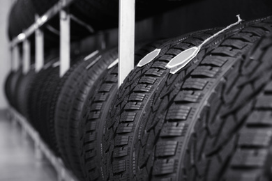 Car tires on rack in auto store, closeup