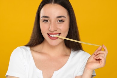 Photo of Happy young woman with bubble gum on yellow background