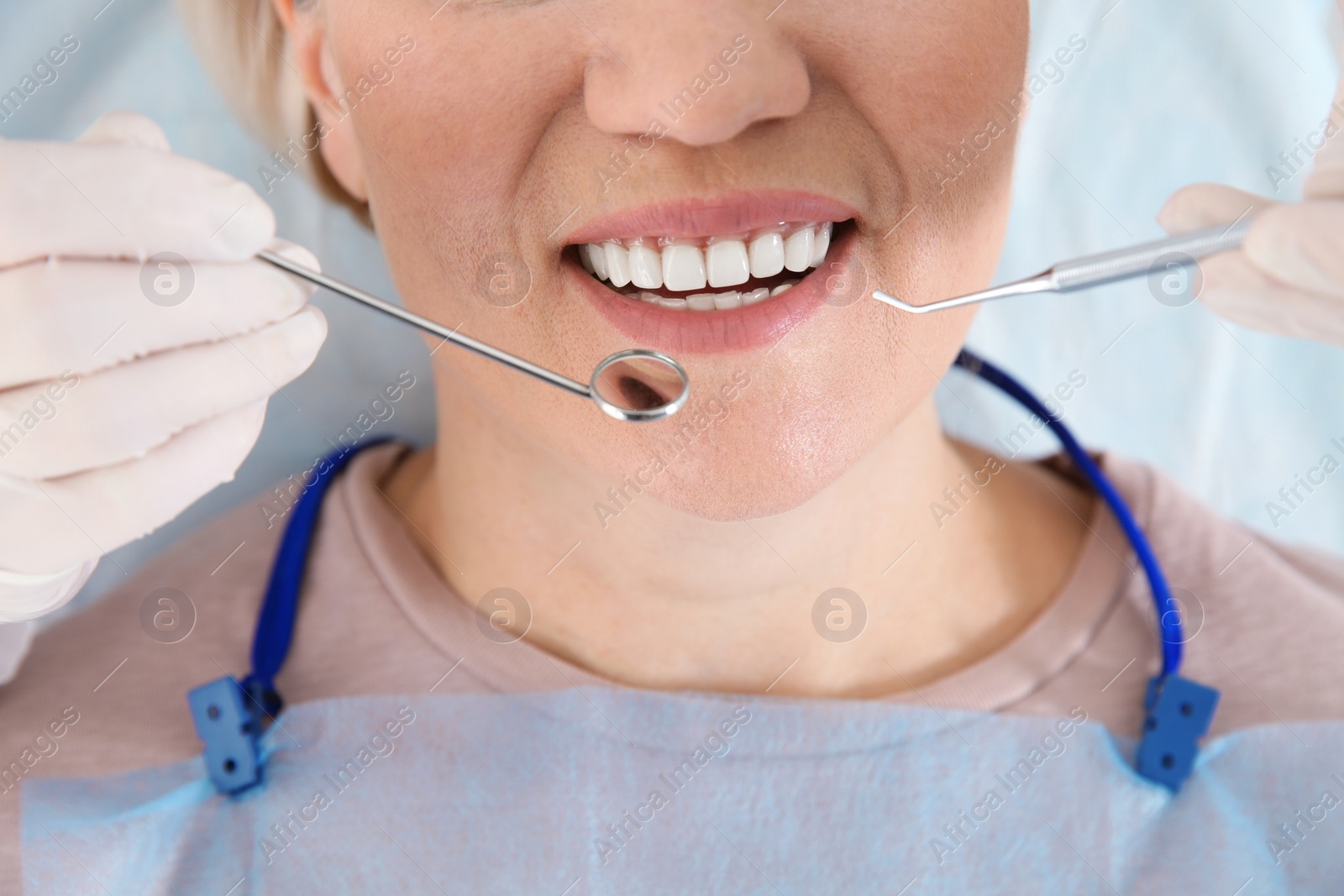 Photo of Dentist examining patient's teeth in modern clinic, closeup