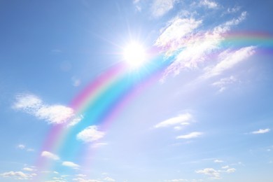 Image of Beautiful view of bright rainbow in blue sky on sunny day