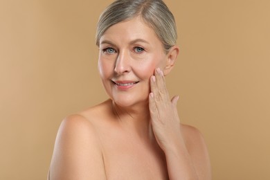 Photo of Beautiful mature woman with healthy skin on beige background