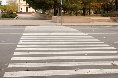 Photo of White pedestrian crossing on empty city street