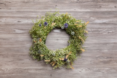 Beautiful wreath made of wildflowers on wooden background, top view