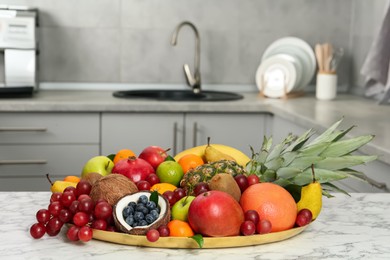 Photo of Assortment of fresh exotic fruits on white marble table in kitchen