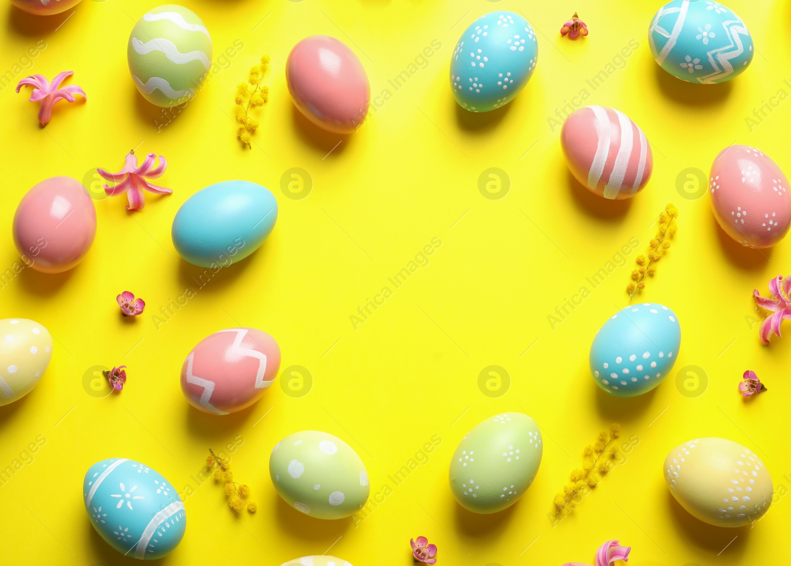 Photo of Frame made of painted Easter eggs on color background, space for text