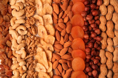 Mix of delicious dried nuts and fruits as background, top view