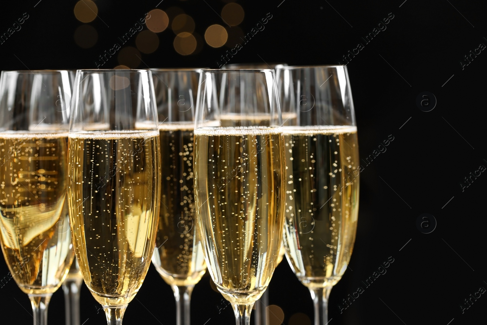 Photo of Many glasses of champagne on blurred background, closeup