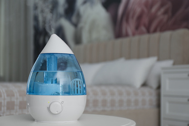 Modern air humidifier on table indoors. Space for text